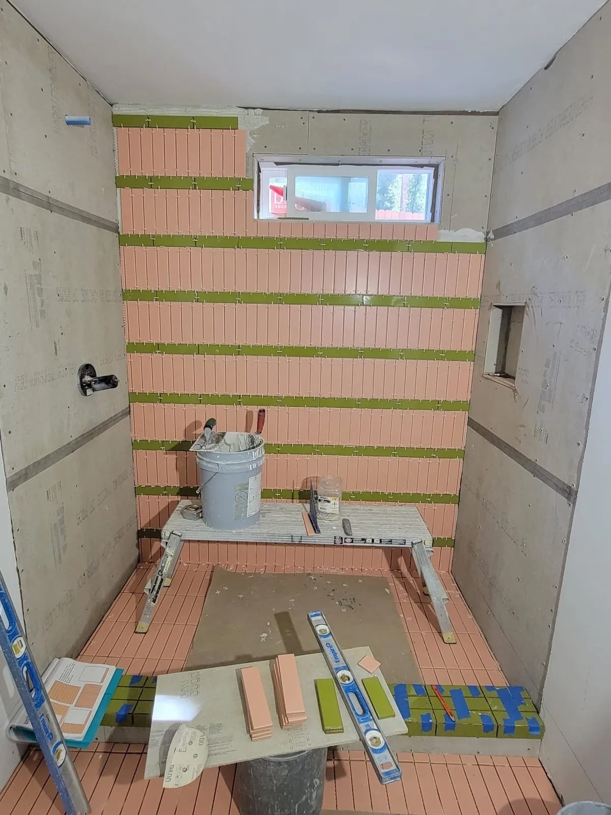 Tile installer preparing and aligning a shower tile installation